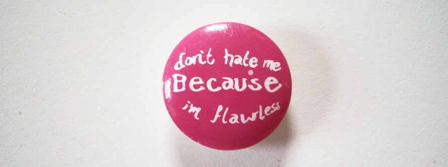 Round rasberry and in white script Dont hate me because I am flawless 7/8" with shank back poly button.