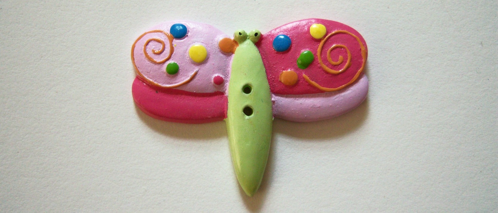 JHB Flutter butterfly lime and pinks 2" two hole polyresin button.