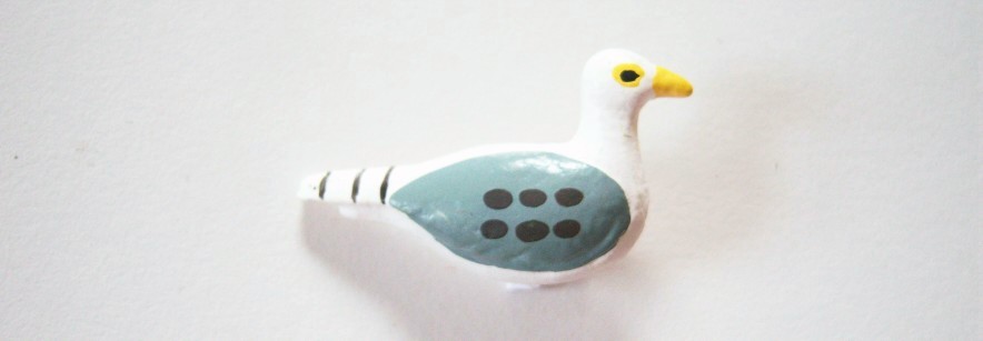 White and blue bird yellow beak 3/4" x 1 1/4" shank back clay button.